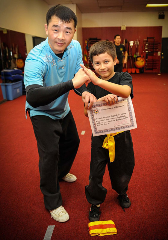 Student celebrating his successful belt test with Master Wu